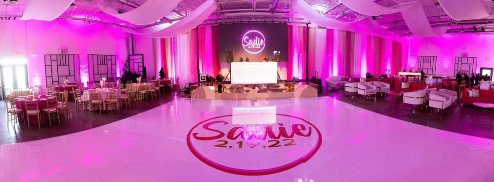 A vibrant pink and white ballroom set up for a celebration.